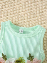 Close-up of a mint green baby girl's dress with floral embroidery, suitable for ages 3-6 months.