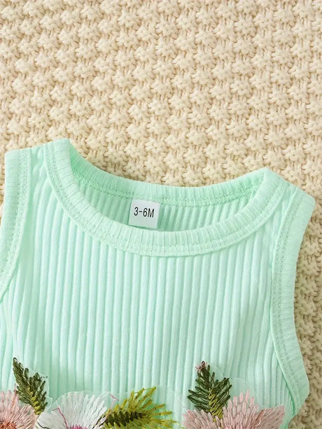 Close-up of a mint green baby girl's dress with floral embroidery, suitable for ages 3-6 months.