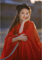 Woman in a beautiful red Hanfu dress smiling, ideal for cosplay and traditional events.
