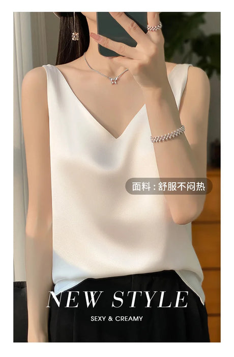 Woman wearing a white satin V-neck camisole top styled with elegant accessories.