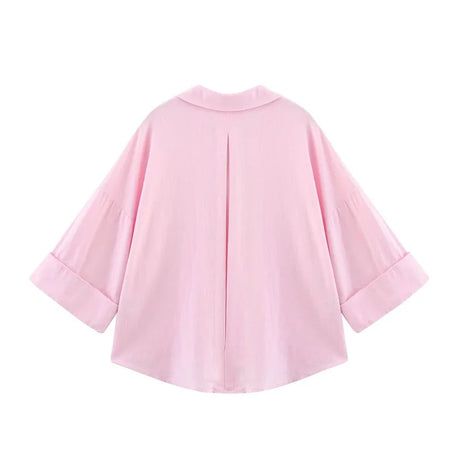 Back view of a loose-fit oversized pink striped shirt with turn-down collar and wide sleeves.