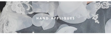 Close-up of elegant hand appliques on fabric, showcasing intricate detailing and craftsmanship.