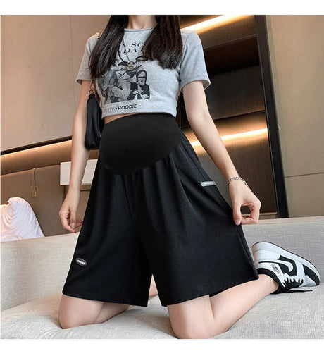 Plus size wide leg maternity pants in black, designed for comfort during summer, featuring a loose fit for pregnant women.