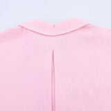 Close-up of the back neckline and pleat detail of a pink blouse with a turn-down collar.