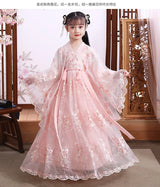 Elegant girl in a pink modern fairy hanfu cosplay dress with floral details and flowing sleeves.