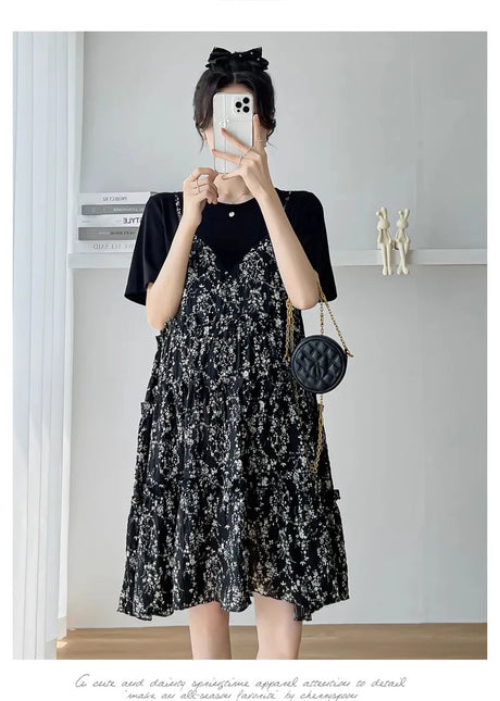 Elegant black floral maternity dress with ruffled layers, perfect for summer baby showers and stylish outings.