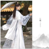Men's Martial Arts Hanfu outfit featuring a traditional design and parasol, showcasing elegance and cultural style.