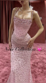 Sparkling pink evening gown with beaded embellishments from new collection, showcasing a fitted silhouette.