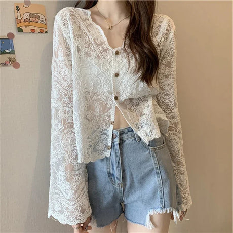 SheerCharm™ white lace sun shirt with long sleeves and buttons, paired with denim shorts for a stylish summer look.