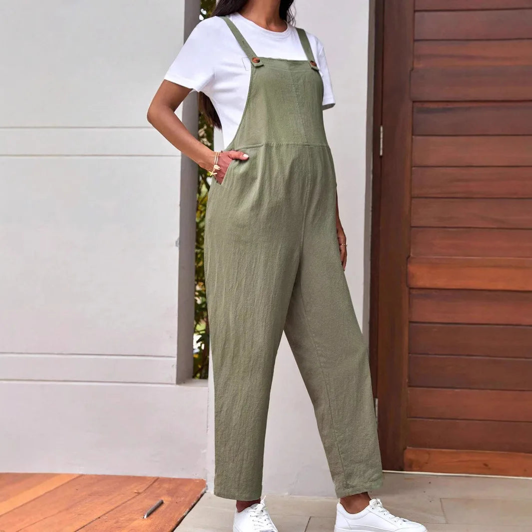 Adjustable maternity overalls in olive green, perfect loose-fit bib pants for women, styled with a white t-shirt and sneakers.