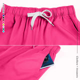 Close-up of pink women's medical scrub pants showing elastic waistband and side pocket with phone.