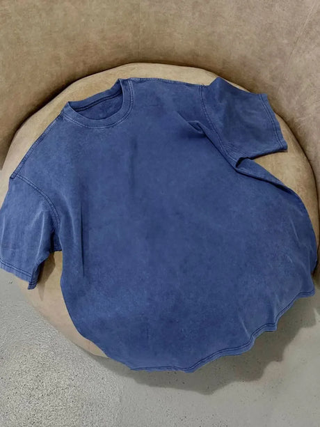 Wolfeel casual blue wax printed t-shirt displayed on a round chair, highlighting its loose fit and comfortable fabric.