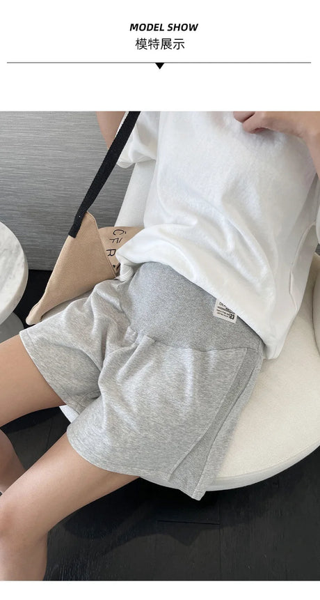 Model wearing gray plus size adjustable maternity shorts, showcasing a loose capri style, perfect for summer comfort.