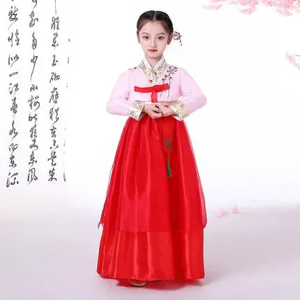 Girl in traditional Korean hanbok with pink and red dress, showcasing cultural attire inspired by Asia-Pacific heritage.