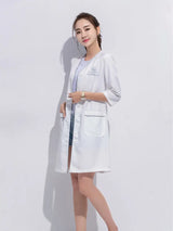 Model wearing a custom white short sleeve lab coat designed for beauty and spa professionals.