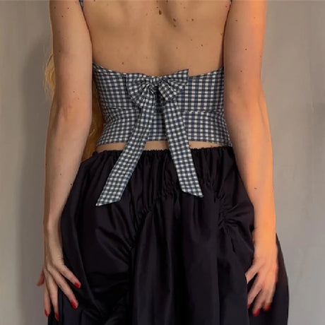 Back view of a plaid bow backless Y2K crop top, styled with a black skirt, showcasing trendy streetwear fashion.