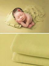 Newborn soft wrap blanket in soothing green color, ideal for photography, featuring an adorable sleeping baby.