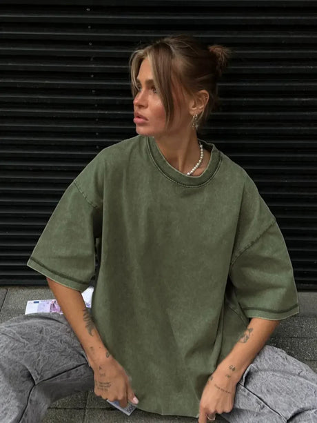 Model wearing a loose-fitting, green casual t-shirt styled with gray pants, showcasing urban fashion.