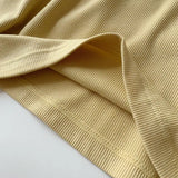 Close-up of the soft, textured fabric of SlimCotz™ padded cotton spaghetti camis in delicate yellow color.