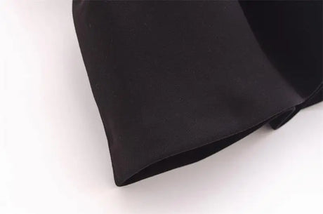 Close-up of the fabric of an elegant black tank top, showcasing its smooth texture and clean stitching.