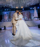 Bride and groom dancing at a wedding celebration in a stunning mermaid dress with a detachable train.