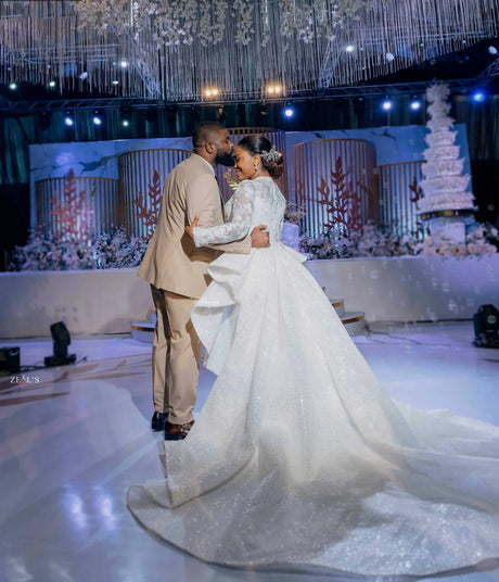 Bride and groom dancing at a wedding celebration in a stunning mermaid dress with a detachable train.