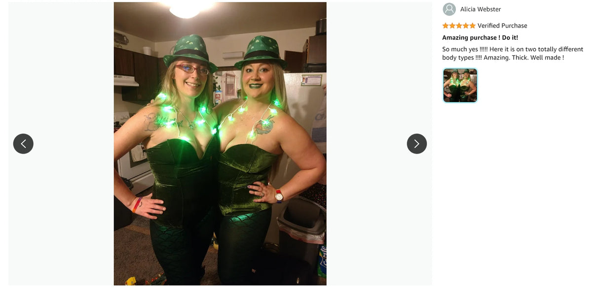 Two women wearing green outfits with glowing accessories, posing joyfully in a kitchen setting.