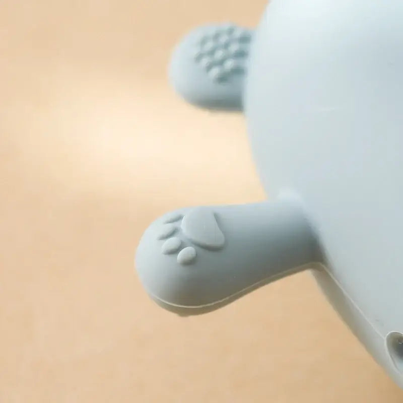 Close-up of soft silicone baby teether glove with cute paw design, ideal for soothing infant gums.