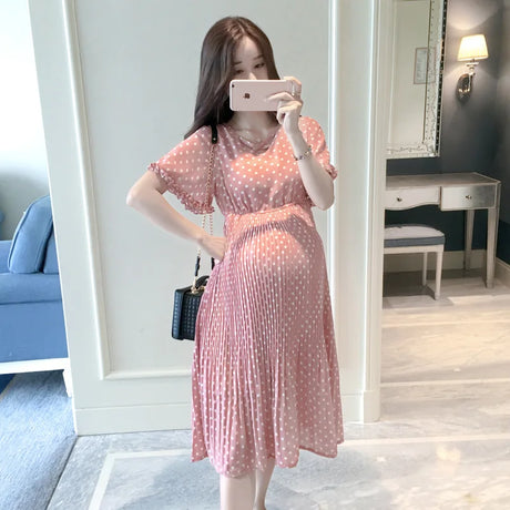Chiffon polka dot maternity dress in pink, featuring a classic boat neck and knee-length pleated design for summer styles.