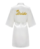 Elegant white satin robe with gold 'Bride' lettering and crown, perfect for bridal celebrations.