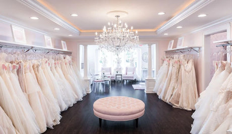 Elegant bridal boutique with white wedding dresses displayed and a chandelier, perfect for brides-to-be.