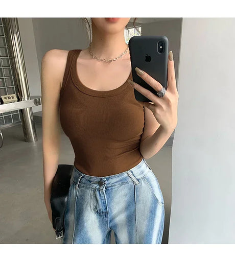 Woman wearing RetroRib™ 90s vintage ribbed tank top in brown, styled with light jeans and a shoulder bag.