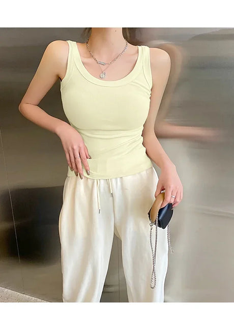 Model wearing RetroRib™ 90s Vintage Ribbed Tank top in light yellow paired with relaxed white pants.