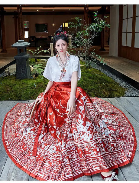Woman in Traditional Hanfu oversized embroidered blouse paired with a vibrant floral skirt, showcasing elegant Chinese fashion.