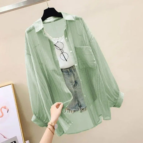 Sheer chiffon sunscreen shirt in light green, paired with a white top and denim shorts. Perfect for spring/summer casual style.