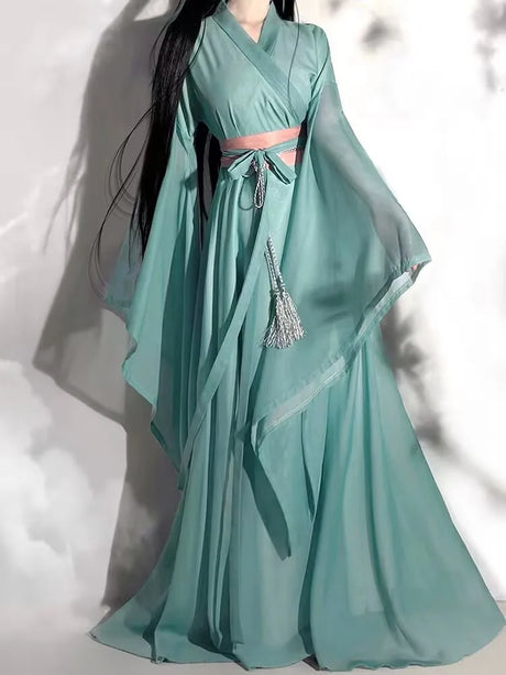 Elegant woman wearing a flowing light green Hanfu costume with bell sleeves and a decorative belt.