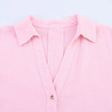 Close-up of a pink oversized striped shirt with a turn-down collar and single-breasted closure.
