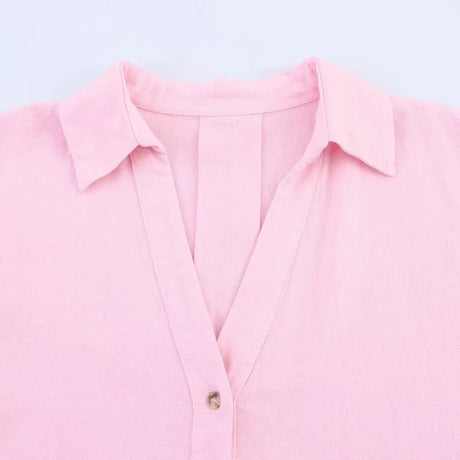 Close-up of a pink oversized striped shirt with a turn-down collar and single-breasted closure.