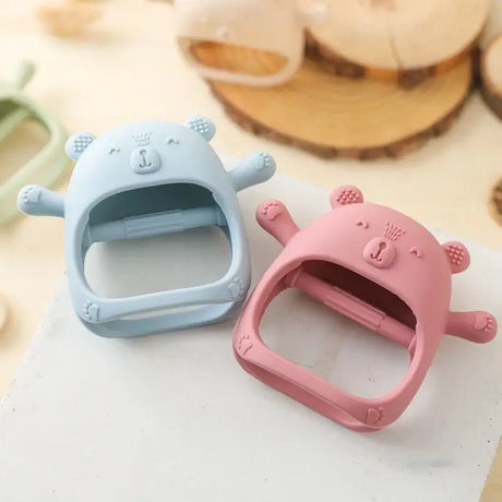 Cute baby teether gloves in soft silicone, pink and blue bear designs for soothing teething pain.