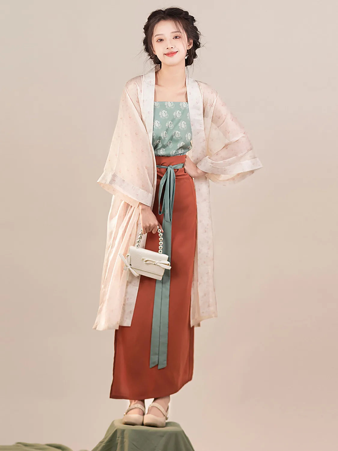 Women in Song Dynasty Hanfu three-piece outfit featuring a stylish green top, flowing robe, and long skirt.