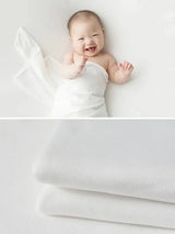 Newborn soft wrap blanket with a happy baby, perfect for photography and comfort, available in 55 colors.