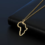 African map gold pendant necklace resting on a black surface, showcasing its unique design and elegance.
