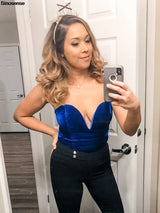 Woman wearing a velvet strapless lace-up bodysuit with a deep neckline, showcasing modern nightwear style.