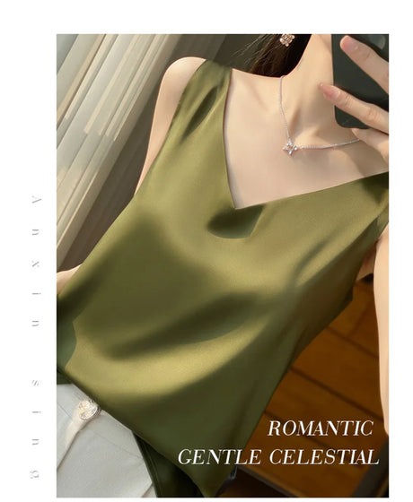Woman wearing a shiny olive green v-neck satin camisole, showcasing a stylish summer look.