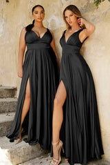 Two women in black V-neck floor-length evening dresses with high slits, showcasing elegant bridesmaid attire.