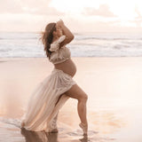 Maternity model in a Boho two-piece outfit on the beach, showcasing a flowing skirt against a sunset backdrop.