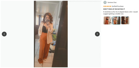 Woman in stylish outfit with orange pants and light blazer in a mirror selfie.
