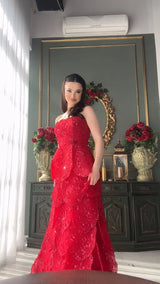 Model showcasing a stunning red tiered engagement gown with lace-up back and intricate beading details.
