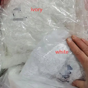 Ivory and white lace fabrics in packaging, suitable for creating bridal wraps and wedding apparel.