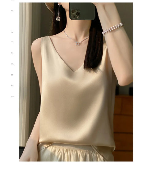 Woman wearing a satin V-neck camisole in beige, showcasing summer elegance and comfort.